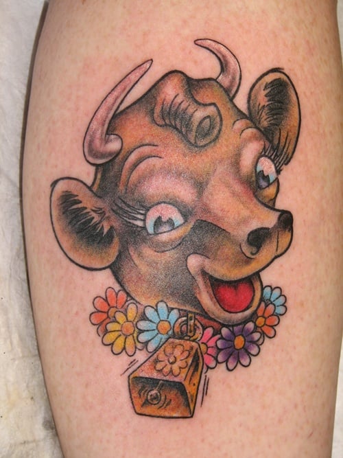 Cow and flowers tattoo located on the forearm