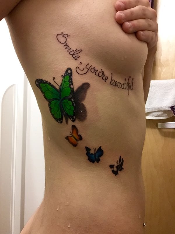 Single needle butterfly tattoo on the ribcage